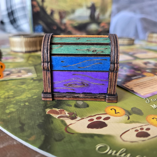 back of everdell gold chest in green, blue, and purple.